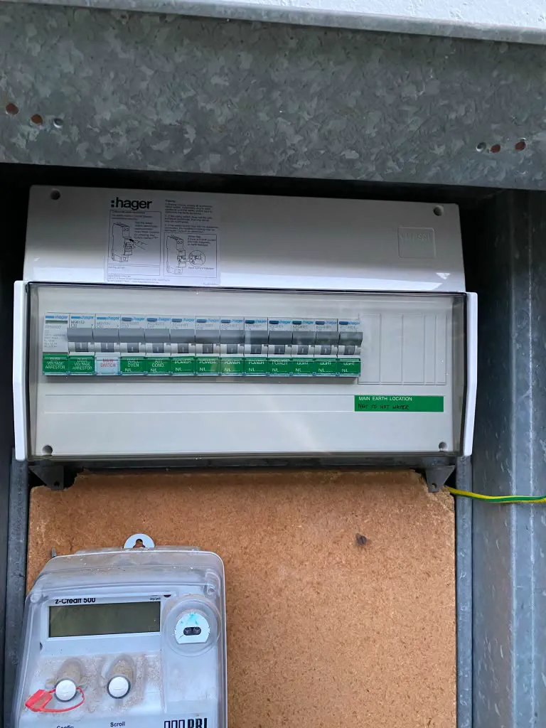 Finished Hager switchboard in an outdoor meter box with the clear cover on, labelled circuits and a main earth location sticker